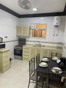 a kitchen with a table and chairs and a kitchen with a stove at أبو بندر للشقق المخدومة in Ar Rass
