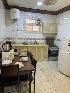 a kitchen with a table with chairs and a refrigerator at أبو بندر للشقق المخدومة in Ar Rass