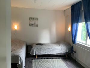 1 dormitorio con 2 camas y ventana en Tomujoen Kylätalo, en Himanka