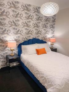 a bed with a blue headboard and two tables with lamps at Darling Harbour stunning city location with pool, gym, wifi, Netflix in Sydney