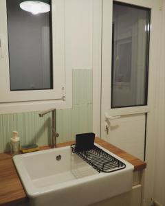 a kitchen with a white sink and a window at MimaDart Pop-up Gallery Apartment in Piraeus