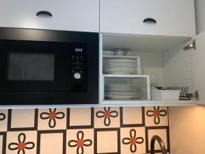 a kitchen with a microwave and some plates and dishes at Design studio Margherita in Cinisello Balsamo +10 photos