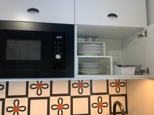 a kitchen with a microwave and some plates and dishes at Design studio Margherita in Cinisello Balsamo