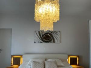 a bedroom with a bed and a chandelier at Guesthouse Villa Stanger 2 in Lovran