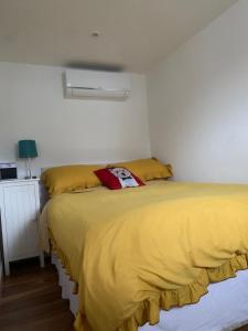 - une chambre avec 2 lits avec des draps jaunes et une lampe dans l'établissement Lindas LODGE Free PARKING air con plus provisions included, à Hove