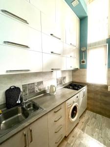 cocina con fregadero y lavadora en Old Batumi Apartment en Batumi