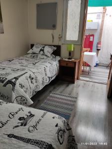 1 dormitorio con 2 camas y TV en la pared en Hospedaje Lago Llanquihue, en Llanquihue