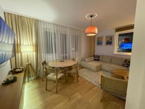 a living room with a couch and a table at Złoty Apartament in Krynica Zdrój