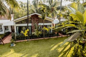 una vista exterior de una casa con palmeras en Coco Palms Resort, Diveagar, en Diveagar