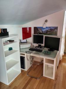 a computer desk with two monitors on top of it at Tuscany MagiC House in Figline Valdarno