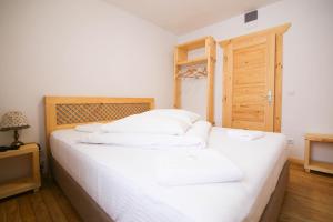 - un lit blanc avec des oreillers blancs dans une chambre dans l'établissement Cabana Poiana Secuilor, à Predeal