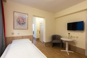 a room with a bed and a table and a tv at Hotel Residence in Würzburg