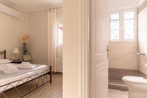 La salle de bains blanche est pourvue de toilettes et d'un lavabo. dans l'établissement Villa Katrin, à Pylos