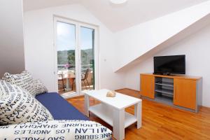 a living room with a couch and a tv at Apartments Vala in Vela Luka