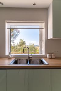 a kitchen with a sink and a window at Villa Katrin in Pylos