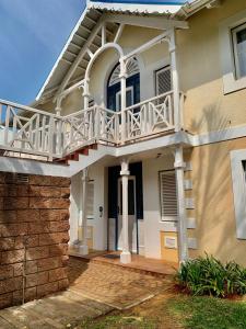ein Haus mit einem Balkon und einer Treppe in der Unterkunft 43 Montego Bay, Caribbean Estate in Port Edward