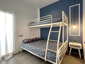 1 dormitorio con 2 literas y pared azul en Maritime Apartamentos Valencia en Valencia