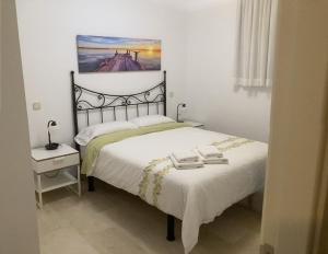 1 dormitorio con 1 cama y una pintura en la pared en BEACH SIDE, en Puerto de Mogán