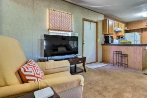 a living room with a couch and a tv and a kitchen at Cozy Gulf Breeze Home, 3 Mi to East Bay! in Navarre