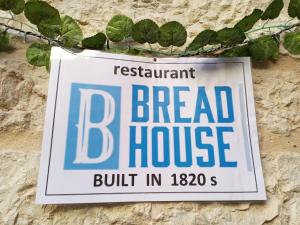 un panneau pour une maison de pain suspendue sur un mur dans l'établissement BREAD HOUSE, à Bethléem