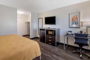 a hotel room with a bed and a desk and a television at Quality Inn Burbank Airport in Burbank
