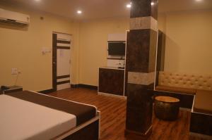 a hotel room with a bed and a kitchen at Hotel WB40 in Durgāpur