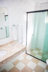 a bathroom with a glass shower and a sink at Lisboa Hotel in Poços de Caldas