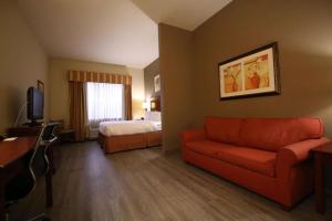 a hotel room with a couch and a bed at Seffner Inn and Suites in Seffner