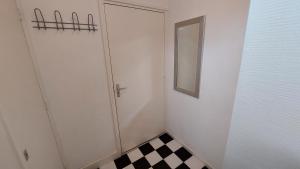 een badkamer met een deur en een geruite vloer bij Studio Noordstraat 26 in Zoutelande