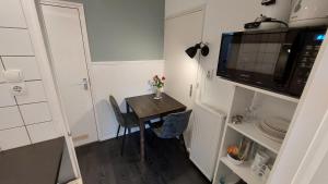 una pequeña cocina con mesa y microondas en Studio Noordstraat 26, en Zoutelande