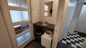 a small bathroom with a sink and a mirror at Studio Noordstraat 26 in Zoutelande