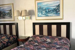 a bedroom with two beds and two pictures on the wall at Travelodge by Wyndham Rockford South in Rockford