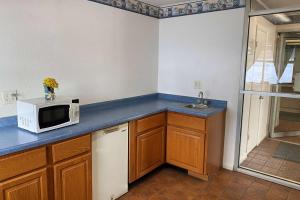 a kitchen with a microwave and a sink at Travelodge by Wyndham Rockford South in Rockford