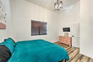 a bedroom with a blue bed and a television at Rural Gilmer House with Covered Patio! in Gilmer