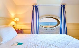 1 dormitorio con cama y ventana con vistas al océano en Residenza D'epoca La Corallina, en Castellabate