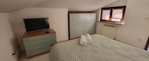 a bedroom with a bed with a tv and a dresser at Residenza Infante in Avezzano