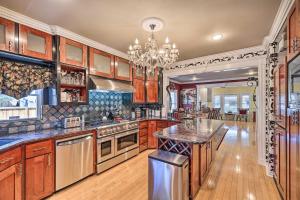 una gran cocina con armarios de madera y una lámpara de araña en Spacious Midtown Houston Home with Deck!, en Houston