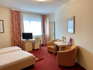 um quarto de hotel com uma cama, uma mesa e cadeiras em Gasthof Großmann em Heidenreichstein
