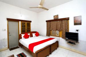 una camera con letto e TV a schermo piatto di Goroomgo Upasana Bhubaneswar a Bhubaneshwar