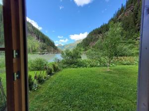 a view from a window of a river and mountains at Tauerndorf Enzingerboden Ski in&out - Steinbock Lodges in Enzingerboden