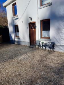 une maison blanche avec deux chaises et une porte dans l'établissement Le refuge de la hoegne, à Solwaster