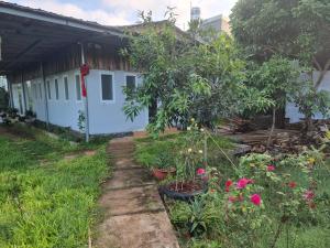 頭頓的住宿－Homestay Sen & Zen Villa Vũng Tàu，一座花园,位于一座种有树木和鲜花的房子前