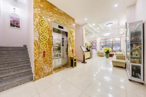 un hall d'un magasin avec un mur en or dans l'établissement Golden Bee Hotel, à Đà Lạt