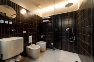 a bathroom with a toilet and a glass shower at Cà Bèla - Pergolesi in Milan