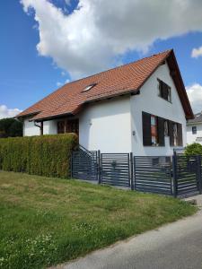 una casa bianca con una recinzione nera di Ferienwohnung der Familie Rauch a Mühlhausen