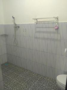 a bathroom with a shower and a toilet at Adila Warung and Homestay in Munduk