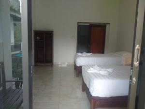 a room with two beds and a balcony at Adila Warung and Homestay in Munduk