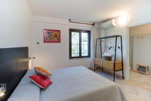una camera da letto con un letto con cuscini rossi di Artemisia negli ulivi b&b a Magliano in Toscana