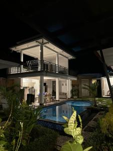 une villa avec une piscine la nuit dans l'établissement Andrew Villa Bali, à Canggu