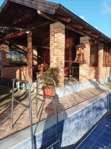 a patio with two chairs on a brick house at Vikendica Raj u prirodi in Prijedor